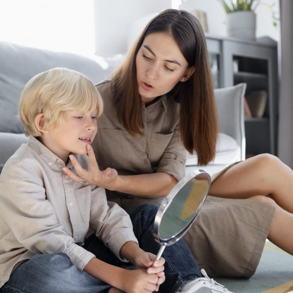 young-woman-doing-speech-therapy-with-little-blonde-boy (1)